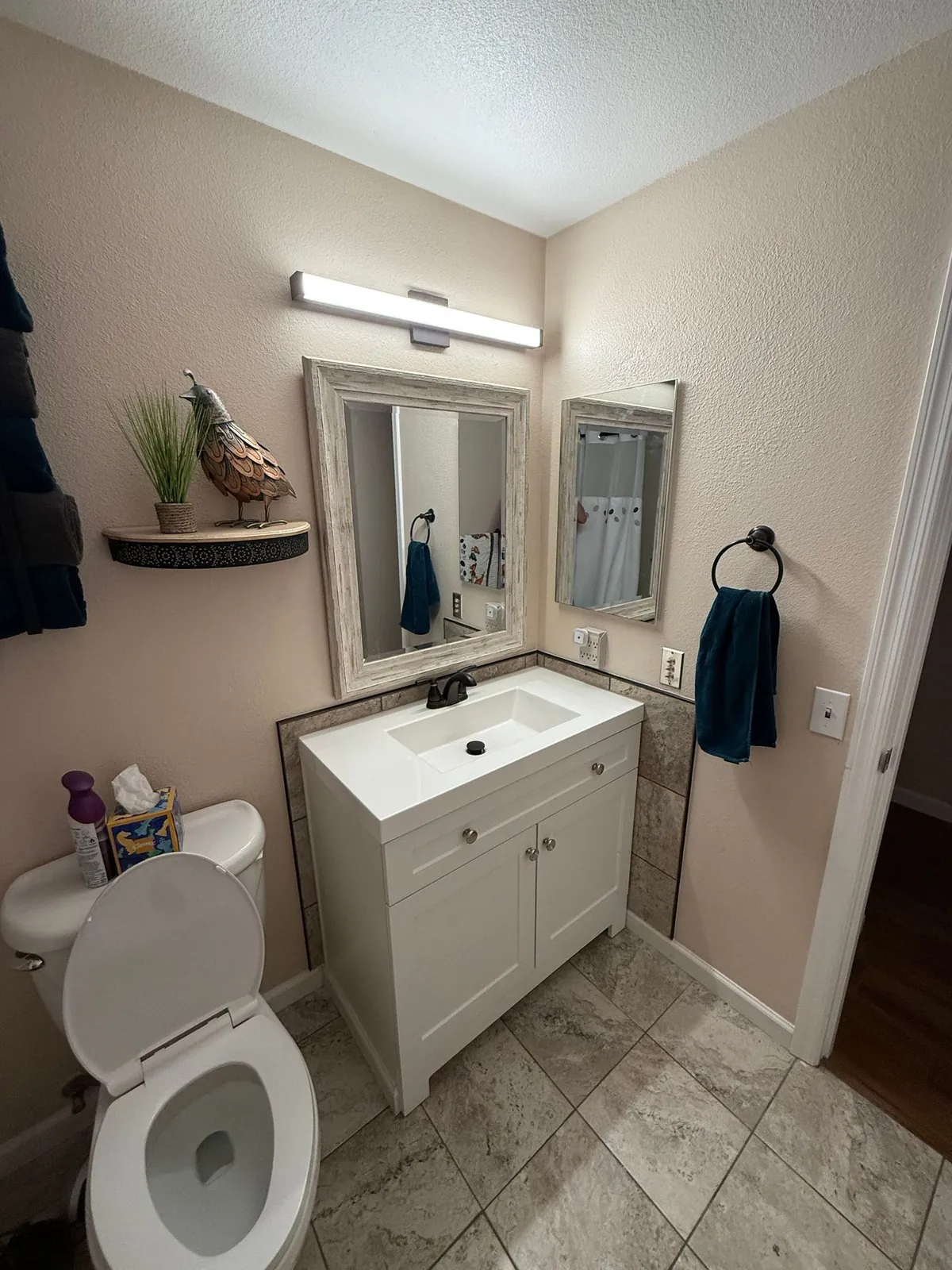 Updated bathroom vanity with tile wainscoting and new faucet