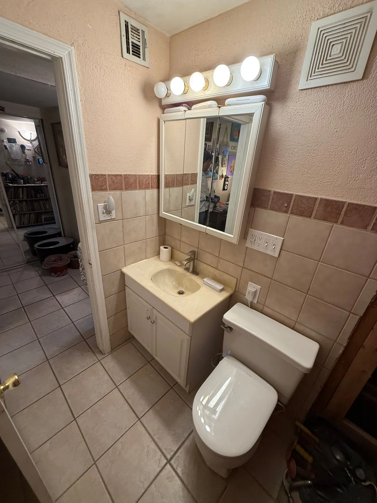 Bathroom with older vanity, medicine cabinet, and tile before remodel
