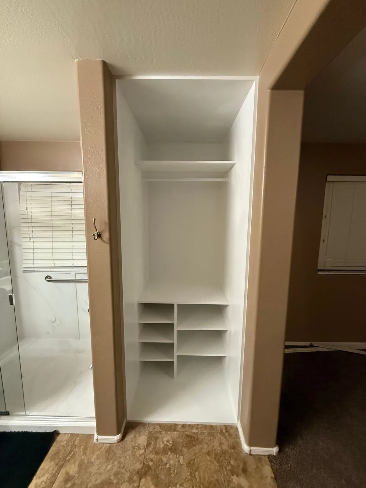 Custom closet build-out with shelving cubbies and hanging rod