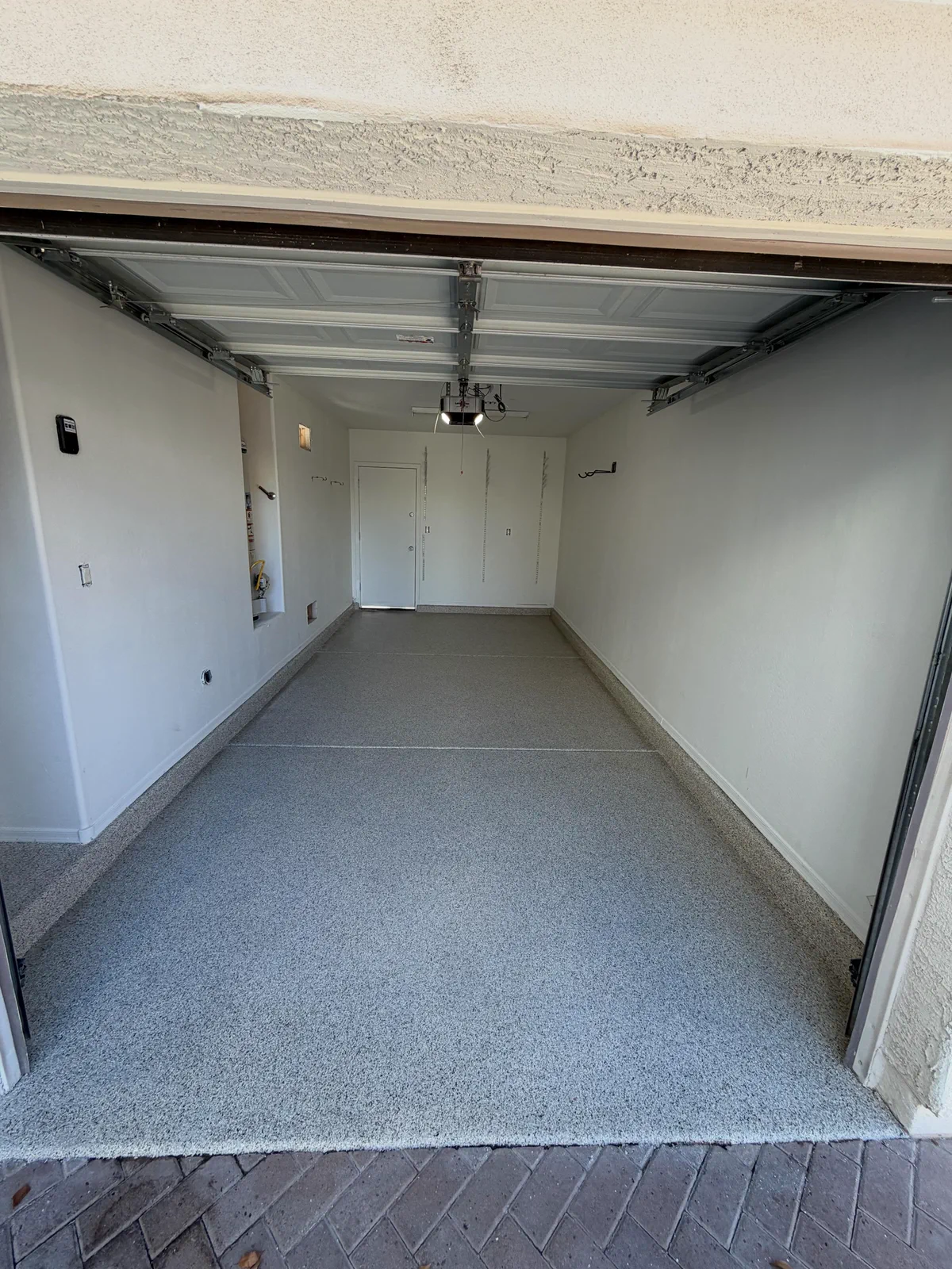Completed garage floor coating viewed through the open garage door